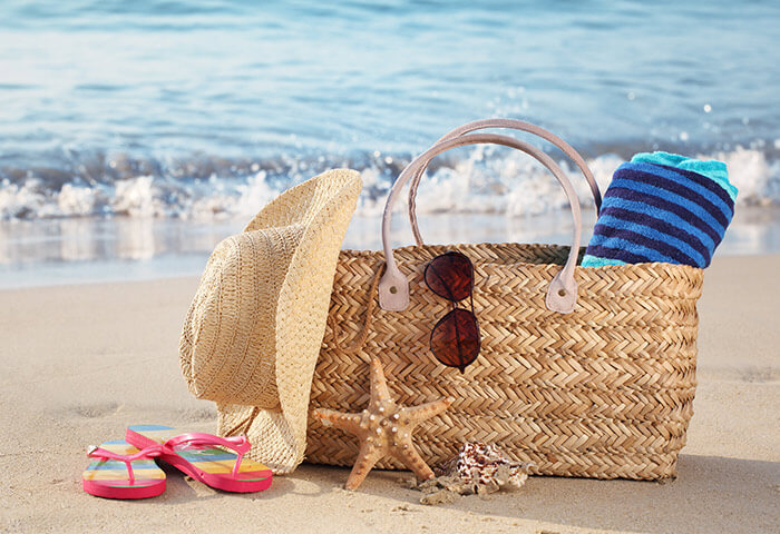 Beach bag with towel, hat, sunglasses, and shoes at a top Kennebunkport beach