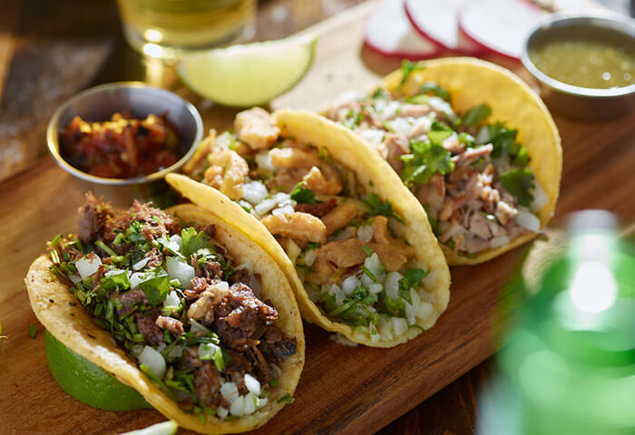 Street tacos on a wooden plate