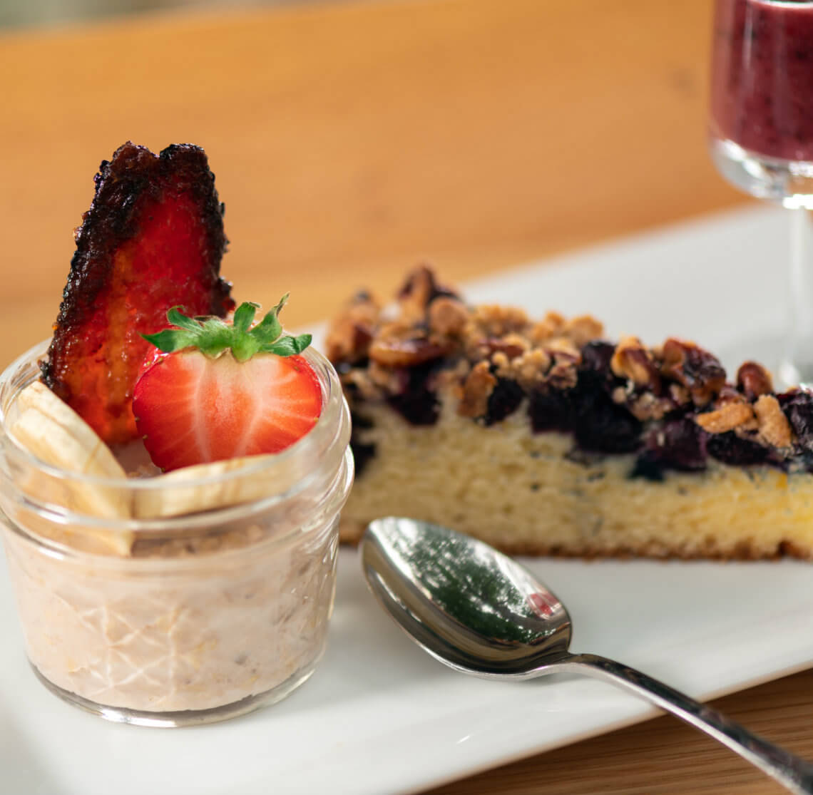 Fruit in a cup with yogurt, blueberry crumb cake and a shiny silver spoon